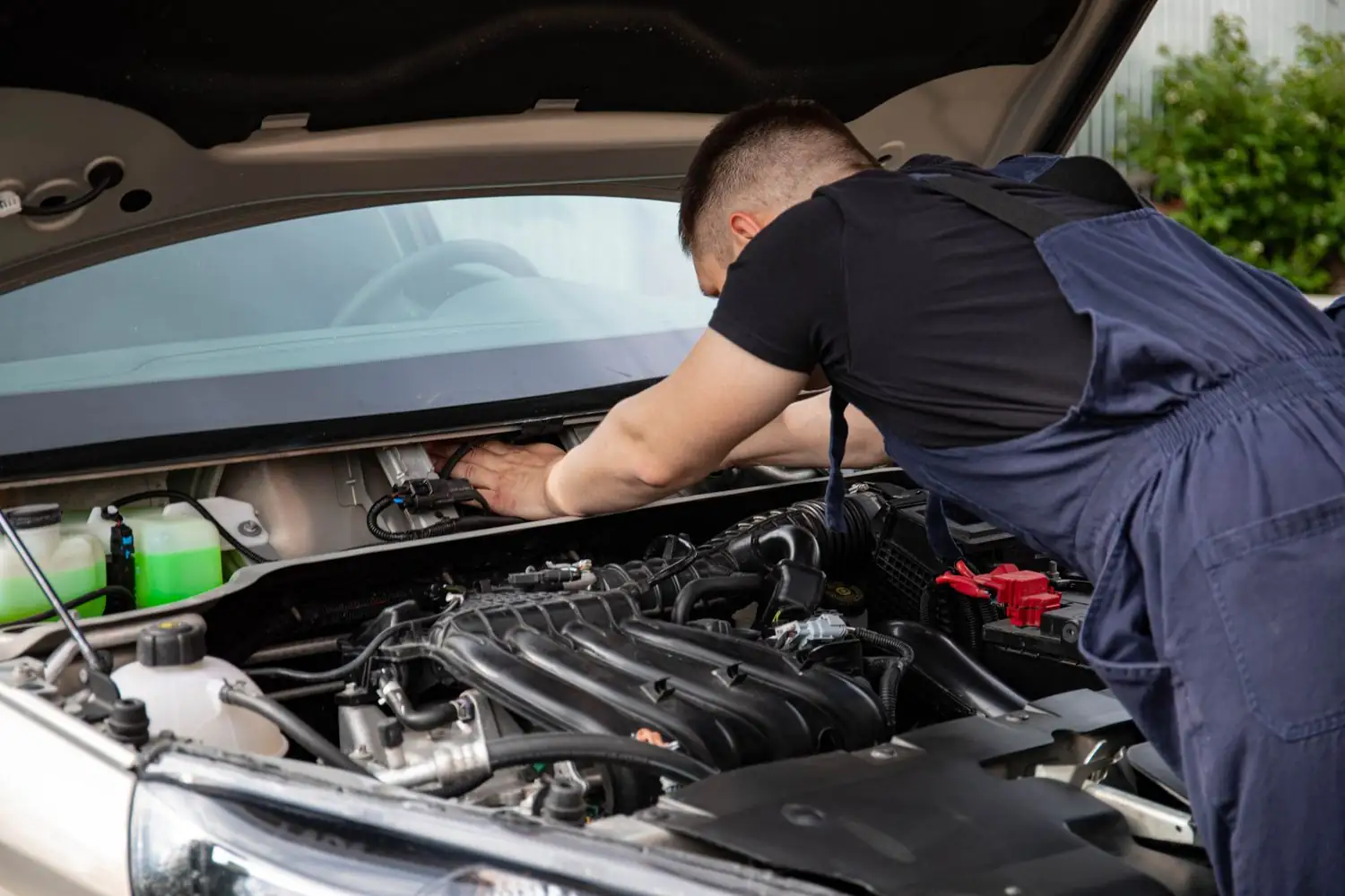 A motor mechanic working under a bonnet