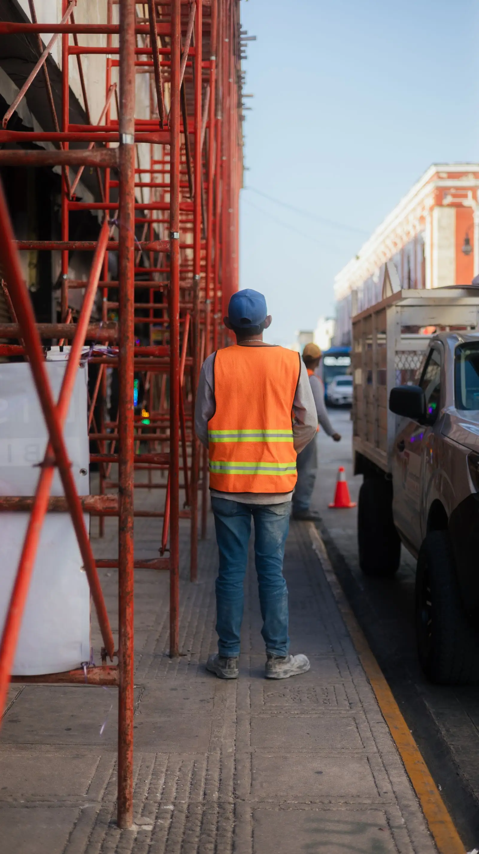An artisan beside scaffolding on a city job