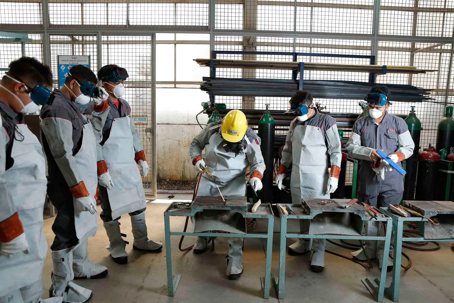Apprentices watching a welding demonstration in a training workshop