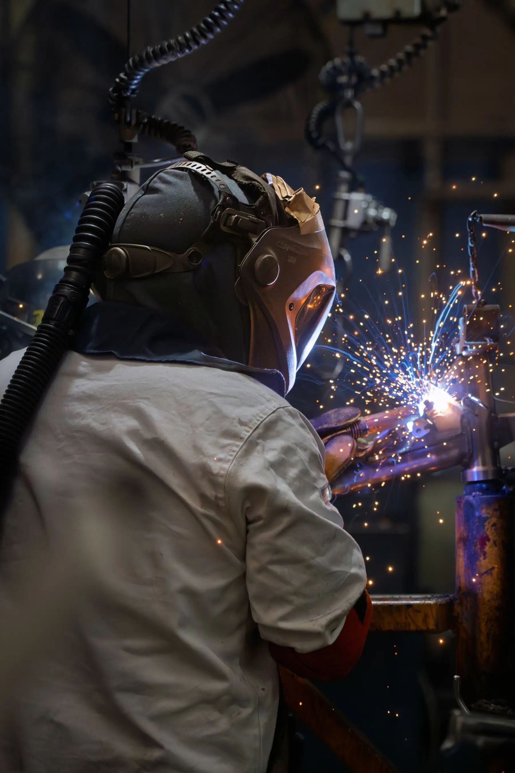 A welder striking an arc in a South African workshop